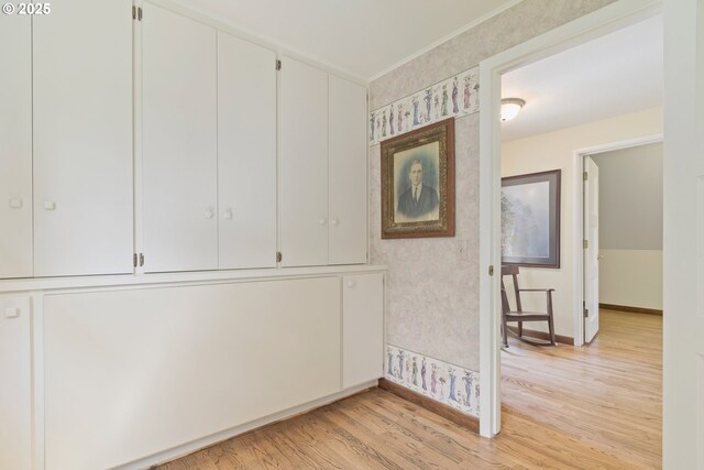 interior space with crown molding, baseboards, and light wood-style flooring