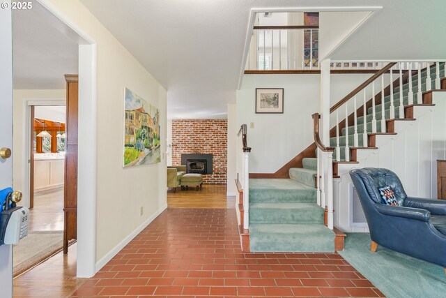 staircase with baseboards and a fireplace
