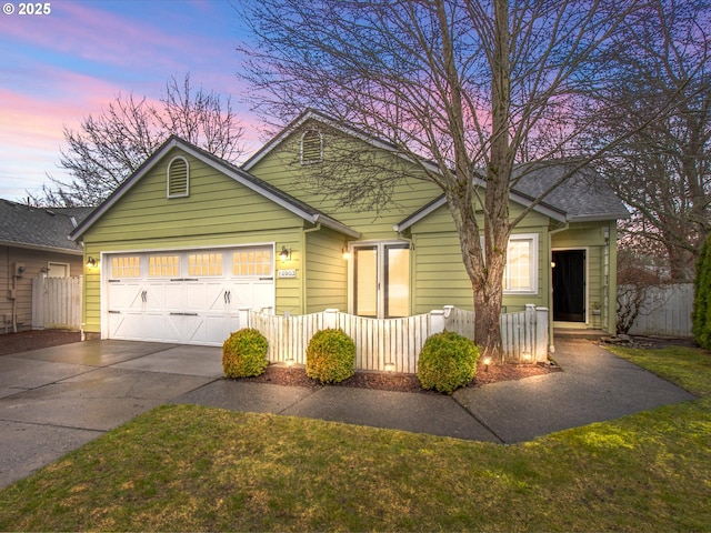 view of front facade featuring concrete driveway, fence, and an attached garage