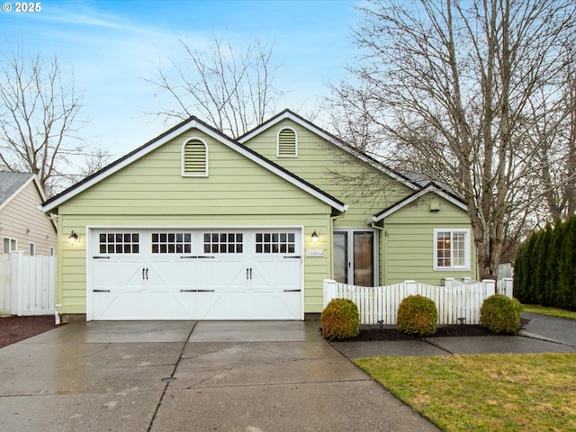 view of front of house featuring concrete driveway, fence, and an attached garage