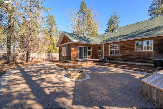 rear view of house featuring central AC, a patio, and a fire pit