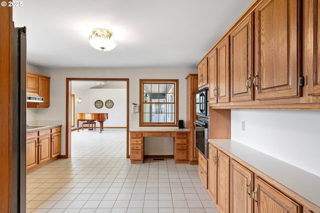 72210 Woodson Ln, Cottage Grove, OR 97424 - kitchen featuring black appliances, light countertops, brown cabinets, and ventilation hood
