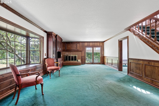 72210 Woodson Ln, Cottage Grove, OR 97424 - carpeted living area featuring ornamental molding, a fireplace, a textured ceiling, and wainscoting