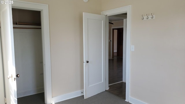 unfurnished bedroom with a closet and baseboards