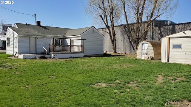 view of yard with an outbuilding, fence, a wooden deck, and a storage unit