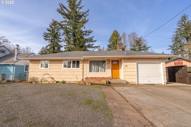 single story home with a chimney, concrete driveway, a garage, and fence