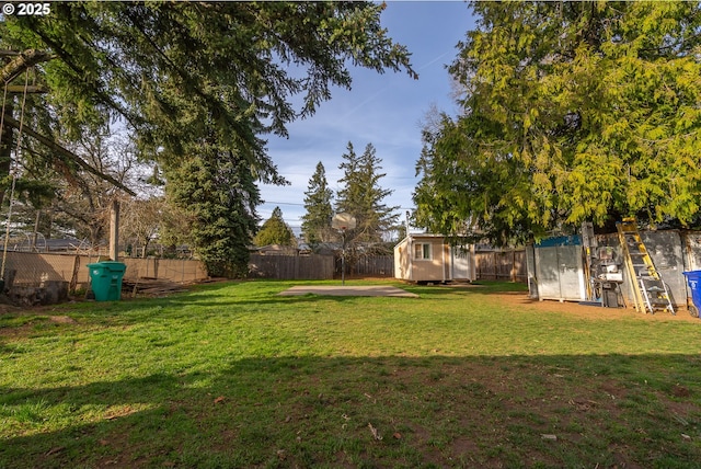 view of yard featuring an outbuilding, a fenced backyard, and a shed