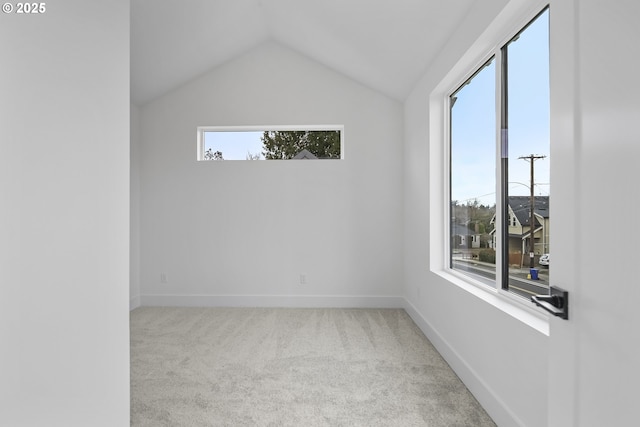 carpeted spare room with lofted ceiling