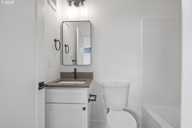 bathroom featuring vanity, a bath, and toilet