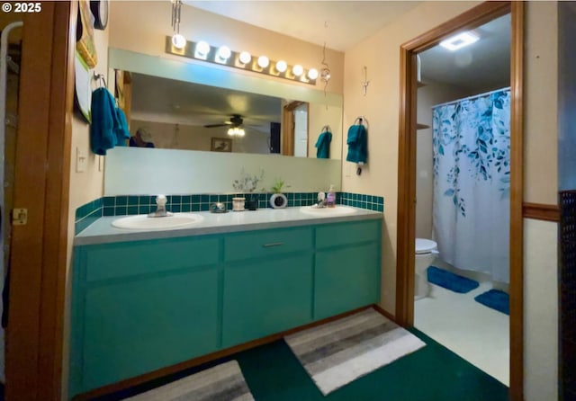 bathroom featuring tasteful backsplash, a sink, toilet, a ceiling fan, and double vanity