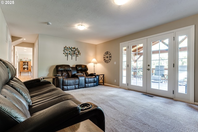 living room with carpet floors, a textured ceiling, french doors, baseboards, and visible vents