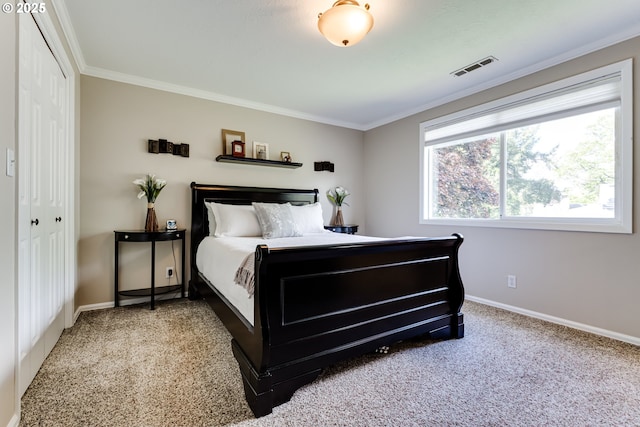 carpeted bedroom featuring baseboards, visible vents, ornamental molding, and a closet
