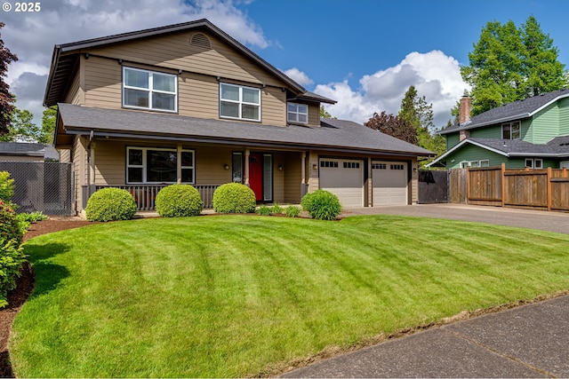 traditional-style house with fence, an attached garage, driveway, and a front yard