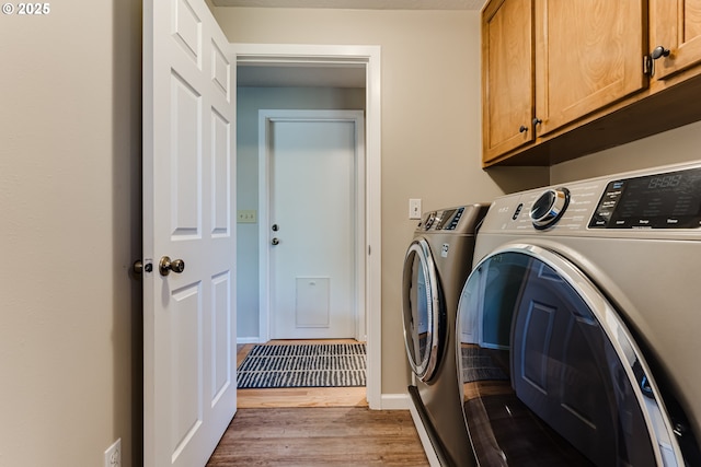 washroom with washer and dryer, baseboards, light wood finished floors, and cabinet space