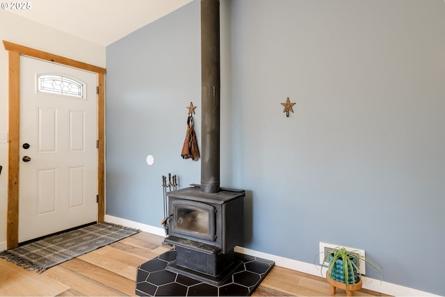 8095 SW High Cone Dr, Terrebonne, OR 97760 - entryway featuring baseboards, a wood stove, and wood finished floors