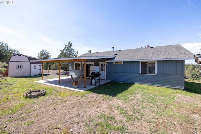 8095 SW High Cone Dr, Terrebonne, OR 97760 - rear view of house featuring an outdoor fire pit, an outdoor structure, a lawn, a patio, and a shingled roof