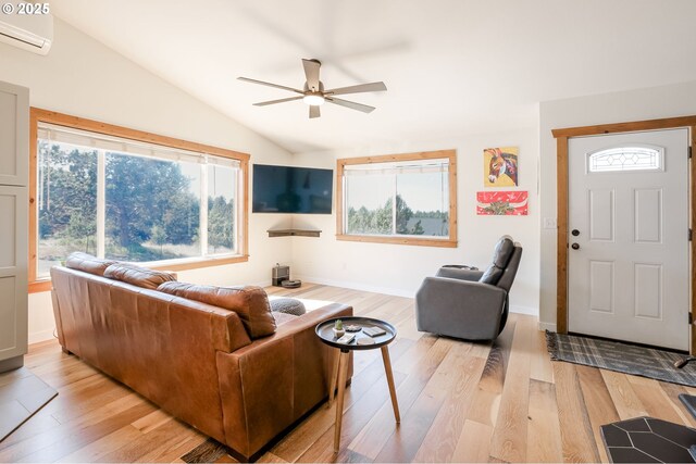 8095 SW High Cone Dr, Terrebonne, OR 97760 - living room with a wall mounted air conditioner, vaulted ceiling, a ceiling fan, light wood-style flooring, and baseboards