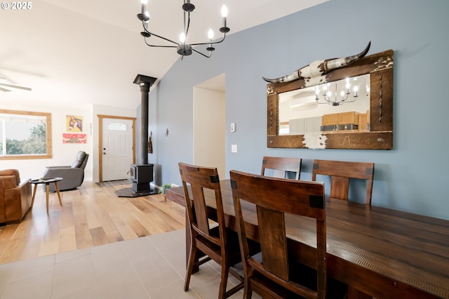 8095 SW High Cone Dr, Terrebonne, OR 97760 - dining area featuring a chandelier, a wood stove, vaulted ceiling, and ceiling fan
