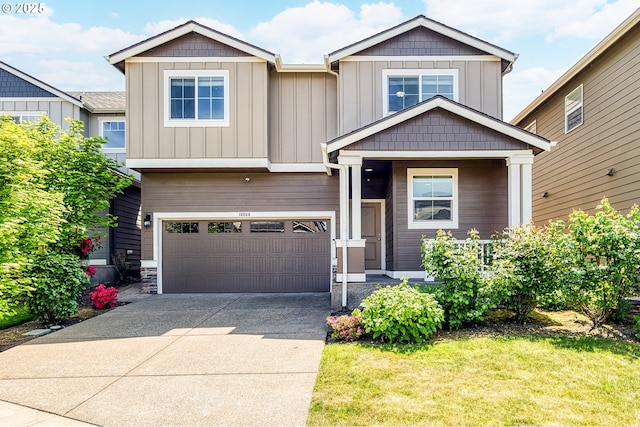 craftsman house with concrete driveway, an attached garage, board and batten siding, and a front lawn