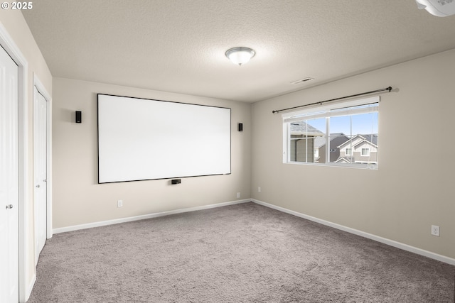 cinema room with carpet floors, a textured ceiling, and baseboards