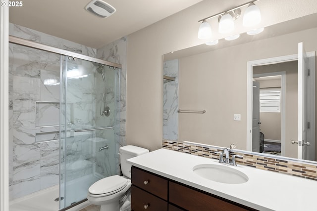 bathroom featuring decorative backsplash, a marble finish shower, toilet, and vanity