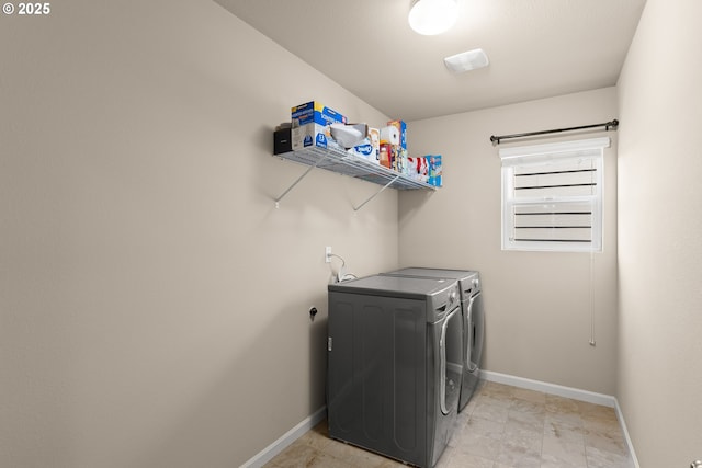 clothes washing area featuring independent washer and dryer and baseboards