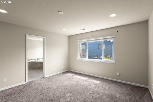 spare room featuring carpet flooring, baseboards, and recessed lighting