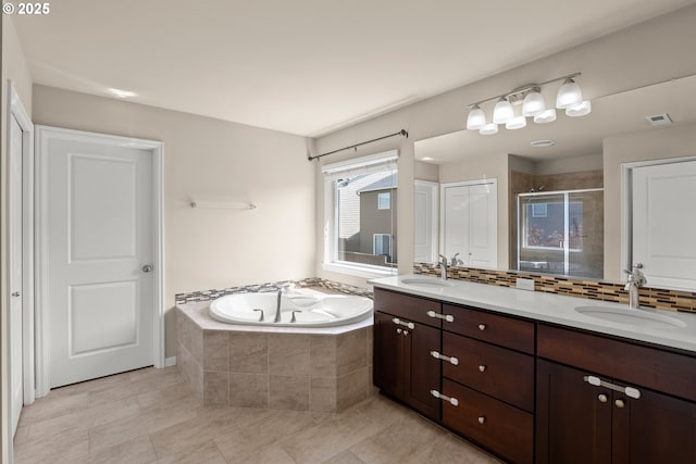 full bathroom featuring a bath, a stall shower, double vanity, and tile patterned flooring