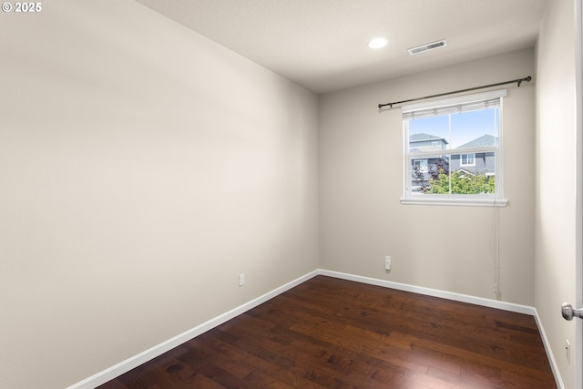 unfurnished room featuring dark wood finished floors, baseboards, and recessed lighting