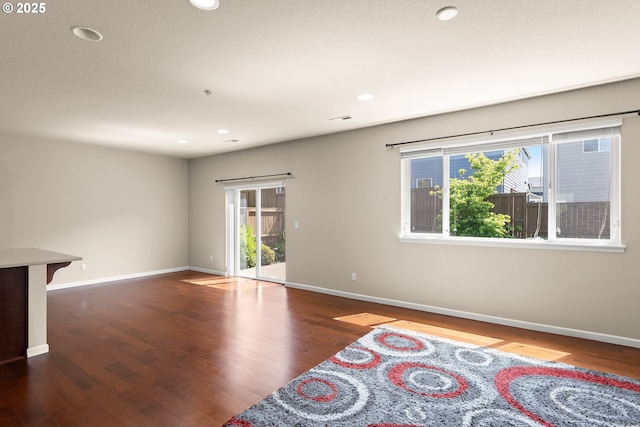 spare room featuring wood finished floors, baseboards, and recessed lighting