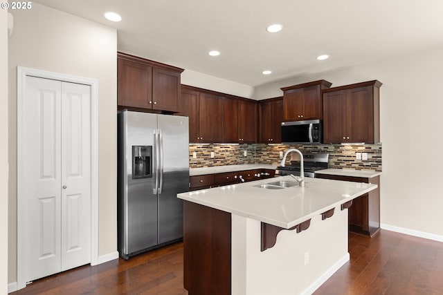 kitchen featuring stainless steel appliances, dark wood-type flooring, decorative backsplash, light countertops, and recessed lighting