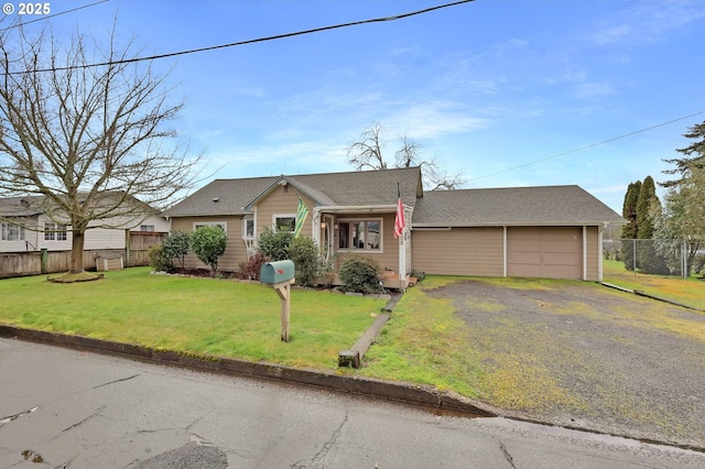 view of front of property with a garage, driveway, a front lawn, and fence