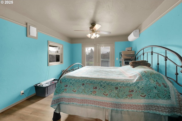 bedroom featuring ceiling fan, french doors, baseboards, and light wood-style floors