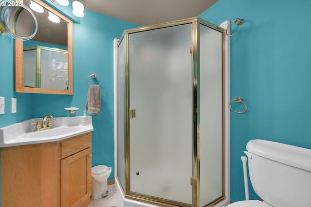 bathroom featuring toilet, a shower stall, and vanity