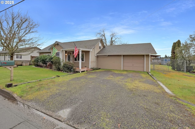 view of front facade with a garage, driveway, a front lawn, and fence