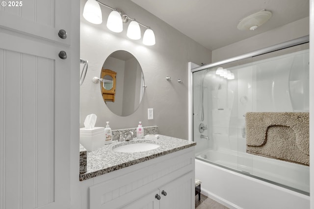 bathroom featuring shower / bath combination with glass door and vanity