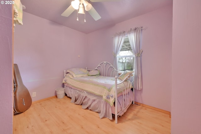 bedroom with baseboards, a ceiling fan, and light wood-style floors