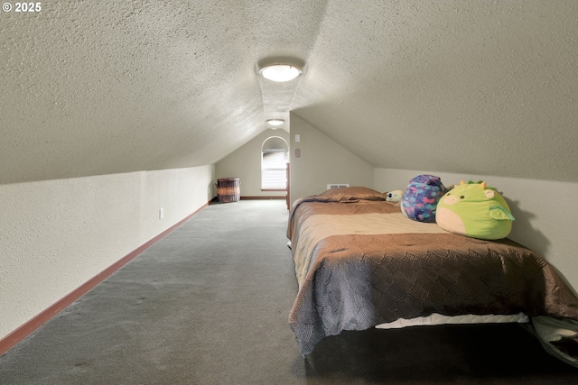 carpeted bedroom with baseboards, vaulted ceiling, a textured ceiling, and a textured wall