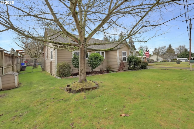 view of home's exterior featuring a lawn and fence