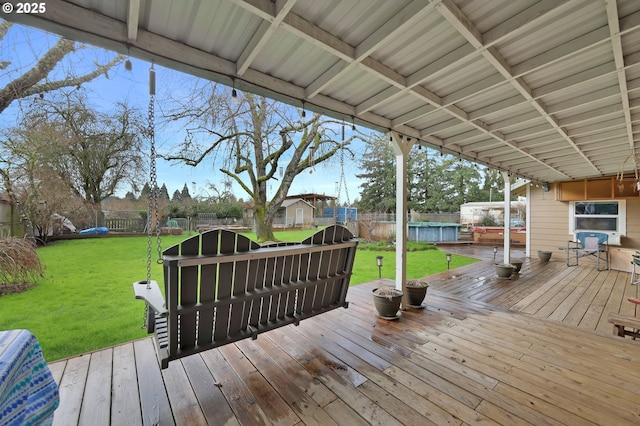 deck featuring a fenced backyard, a pool, and a yard