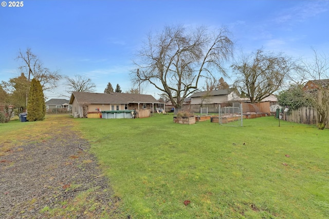 view of yard with a vegetable garden, fence, and a fenced in pool