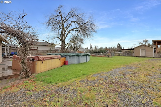 view of yard with a covered pool, fence, and a hot tub