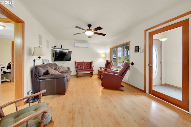 living room with a ceiling fan, wood finished floors, and a wall mounted air conditioner