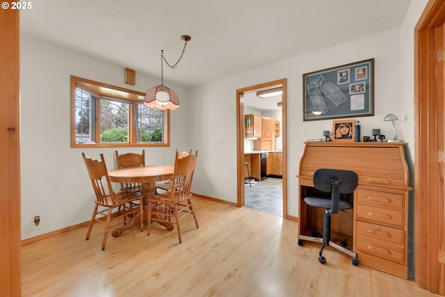 dining room featuring light wood-type flooring and baseboards