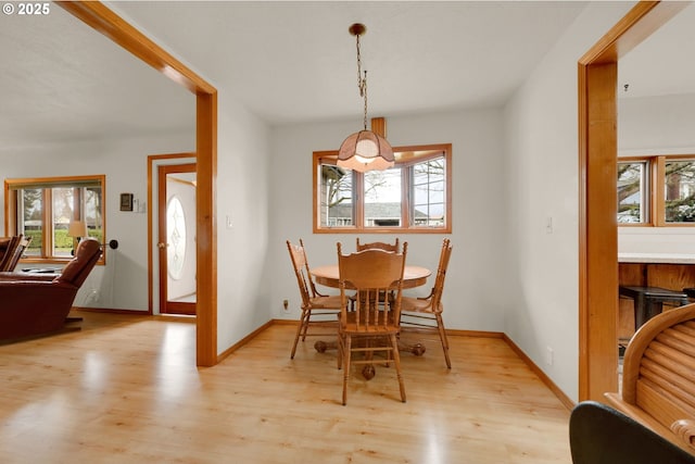 dining area with light wood-style flooring and baseboards