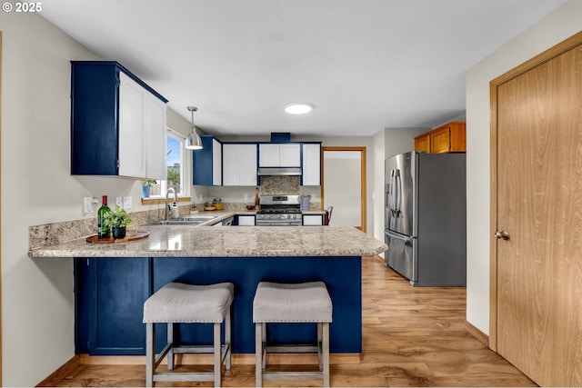 13306 NE 92nd St, Vancouver, WA 98682 - kitchen with appliances with stainless steel finishes, a sink, under cabinet range hood, a peninsula, and light countertops