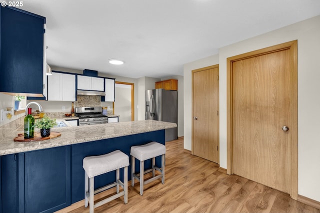 13306 NE 92nd St, Vancouver, WA 98682 - kitchen with stainless steel appliances, a sink, under cabinet range hood, light countertops, and a peninsula