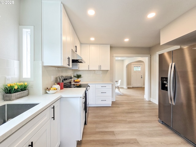 14127 SE Center St, Portland, OR 97236 - kitchen featuring stainless steel fridge, under cabinet range hood, electric range, arched walkways, and white cabinets