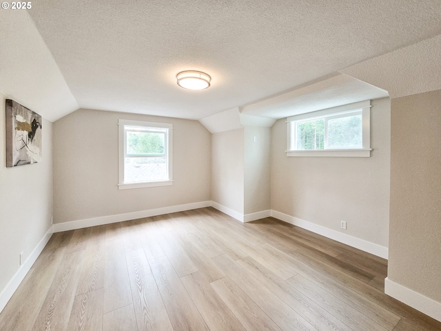 14127 SE Center St, Portland, OR 97236 - additional living space featuring wood finished floors, lofted ceiling, healthy amount of natural light, and a textured ceiling