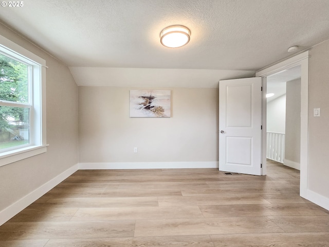 14127 SE Center St, Portland, OR 97236 - empty room with light wood finished floors, a textured ceiling, lofted ceiling, and a smoke detector